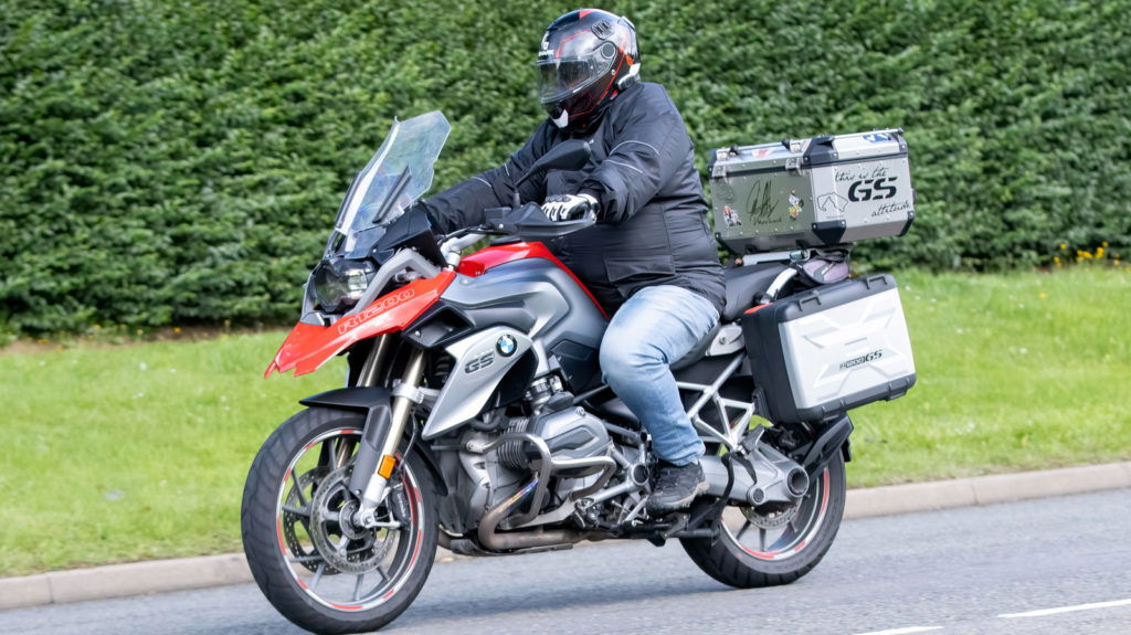 Whittlebury,Northants.,UK - Aug 6th 2023. BMW R1200GS motorcycle travelling through an English village.