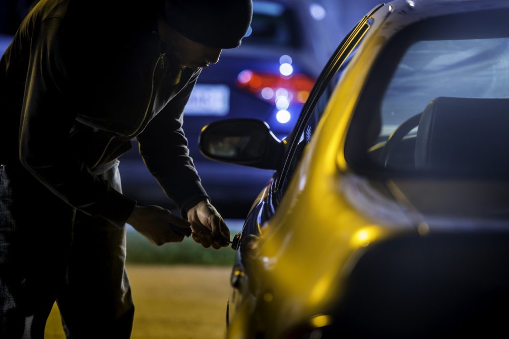 Car thief stealing a car.