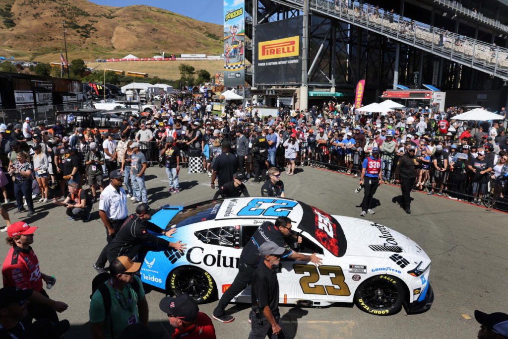 Members of the crew for Bubba Wallace’s car (23) push their car to the track before the start of the Toyota/Save Mart 350 NASCAR Cup Series Race at the Sonoma Raceway in Sonoma, Sunday, June 9, 2024. (Beth Schlanker / The Press Democrat)