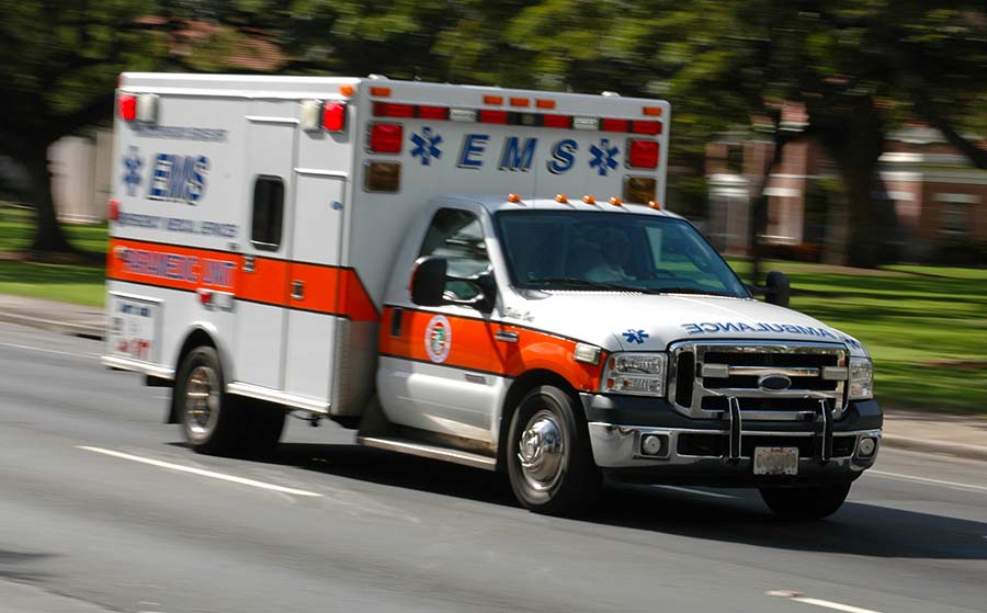 A speeding emergency medical services ambulance, with motion blur