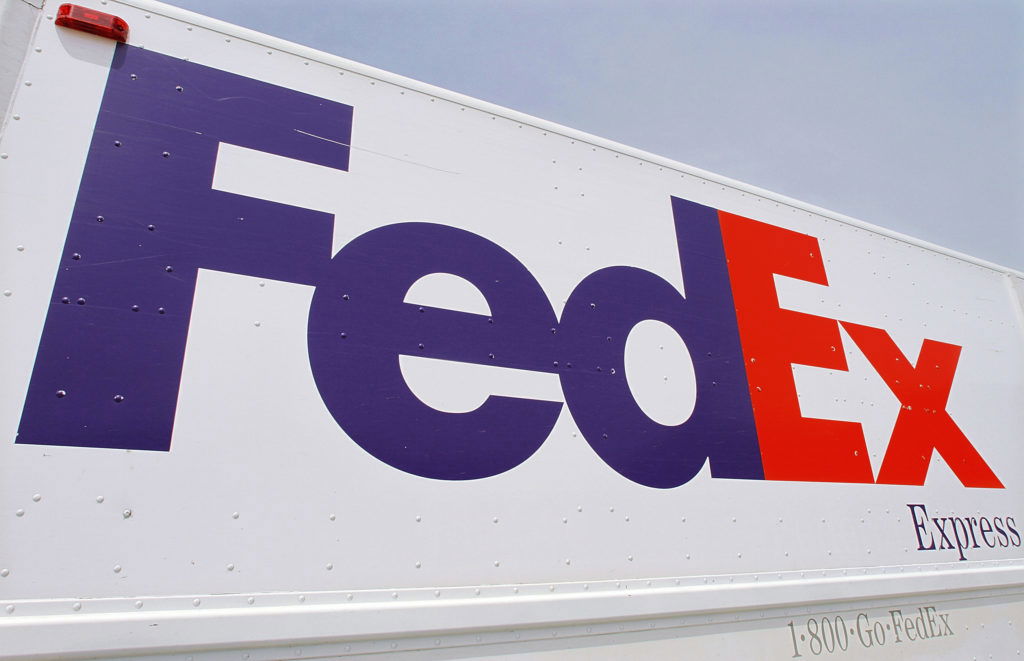 FILE - The FedEx logo is seen on a delivery truck Tuesday, June 21, 2011, in Springfield, Ill. FedEx said Thursday, Sept. 15, 2022, that it is shuttering storefronts and corporate offices while putting off new hires in a belt-tightening drive brought on by drop-off in its global package delivery business. (AP Photo/Seth Perlman, File)