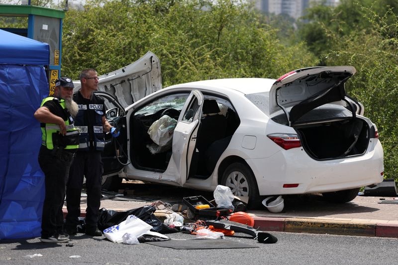 Israeli officials work at the scene of a suspected attack near a junction in Nir Tzvi, Israel, July 14, 2024. REUTERS/Ronen Zvulun