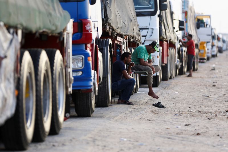 FILE PHOTO: Truck drivers sit near lines of aid trucks for Gaza waiting to be deployed, in Al Arish, Egypt, July 4, 2024. REUTERS/Amr Alfiky/File Photo